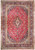 Flat overhead view of red Persian Kashan rug with navy floral border and ivory medallion