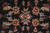 Macro of orange rosettes and lavender leaves knotted on black wool pile ground