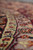 Low angle view across ivory guard stripe and rose border of round traditional rug
