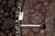 Back tag reading genuine hand woven Oriental rug with tape measure confirming 8 foot diameter