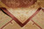 Folded corner of the Chinese wool rug revealing dense pile and neatly finished rust selvage