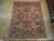 Hand-knotted 7'9" x 9'10" Chobi rug displayed flat on pale wood showroom flooring