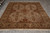 Full view of traditional Indian rug on grey floor with ivory fringe and dense wool pile