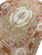 9x13 needlepoint rug angled view showing central medallion, floral swags and rust inner frame