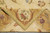 Folded corner showing flat weave reverse, green selvage and acanthus cartouche in gold border