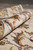 8x10 wool rug rolled back to show pile depth and rust toned florals