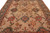 Close field view showing rust medallions, green palmettes and ivory rosettes on soft tan ground