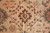 Center detail of dark brown serrated medallion with vine lattice on camel tan wool pile