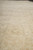 Low angle detail of pale gold wool pile catching daylight across the washed surface