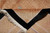 Folded corner revealing cotton fringe, black border and the dense carved wool pile height