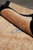 Rolled edge of the square Chinese rug showing lustrous wool and carved relief design