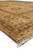 Side profile of the rug corner with cream fringe and layered rust and gold borders