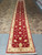 Hand-knotted 3'1" x 19'6" Chobi runner rug photographed on tile and concrete showroom flooring