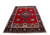 Angled floor display showing red Tabriz rug, black border and salmon panel row across both ends