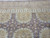 Border bands photographed straight on: cream oval sprigs above the gold fretwork and mauve field