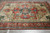 Angled view of hand-knotted wool Serapi rug showing 8 pointed star medallion and borders