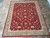 Rug laid on travertine tile floor, seller tag visible at left edge, full pattern shown