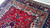 Floor-level view across the red field showing scrolling vines and the salmon spandrel frame