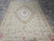 Whole rug seen from one end, medallion centred between four flowered corner panels