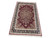 Angled full-length studio shot of the rug lying flat, fringe nearest the camera, white background