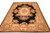 Full rug angled against a white background, black field framed by a wide ivory floral border
