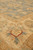 Corner of the rug where the grey-green field turns into the sand-gold border