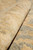 Rolled edge photographed close up, showing the short wool pile and cream border knots