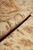 Rolled edge of the rug showing pile depth and the border vine in profile