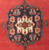 Close view of the octagonal navy medallion with its ivory eight-lobed rosette and brown centre