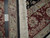 Ruler and hand knotted tag laid across the folded back edge beside the ivory fringe