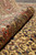 Rug rolled at the border, showing pile depth and the density of the wool surface