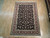 Rug laid flat on pale wood flooring in a warehouse, full length seen from one end