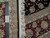 Back of the rug folded over beside a tape measure, knot structure and fringe visible