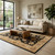 Styled living room with the black and ivory rug under an oak coffee table beside a linen sofa