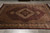 Rug laid flat on grey tile floor, photographed lengthwise, medallion and herati field under even light