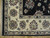 Corner detail of the ivory main border with rosettes, guard stripes and pale cotton fringe