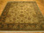 Whole rug laid flat on parquet, ivory field framed by a near-black palmette border