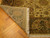 Corner folded back to show the knotted reverse in olive and ivory beside the fringe
