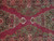 Close view of the field centre where the two medallion pendants meet over raspberry red ground
