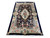 Angled full-length photograph of the rug on white, white fringe visible at the near end