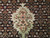 Detail of pile showing diamond lattice rosettes in coral, ivory and red on near-black ground