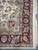 Corner close-up of burgundy main border, ivory guard stripe and long white cotton fringe