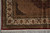 Corner of the rug on grey floor with spandrel, ivory boteh border and fringe