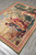 Angled floor view of the whole tapestry showing the olive outer edge and corners