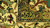 Macro of the ivory border pile showing olive, teal and gold floral motifs in wool
