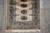 Overhead view of one end, diagonal lattice end panel and ivory fringe on grey tile