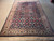 Rug laid flat on a concrete floor, long ivory fringe in the foreground