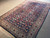Angled floor view showing the indigo field and the wide ivory main border together