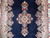 Close view of the central medallion and pendants with flanking floral sprays on navy ground