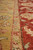 Detail where the gold field meets the salmon guard stripe and the red main border